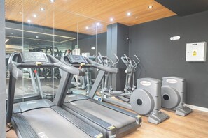 Ein Fitnessstudio mit Laufbändern, Crosstrainern und Ergometer.