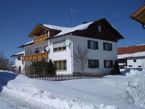 A two-story building with a balcony, satellite dishes, and a snow-covered roof. - Holiday Apartment With 2 Bedrooms (Rosshaupten)