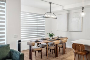 Ein stilvoller Essbereich mit Holztisch, gepolsterten Stühlen und einer Pendelleuchte.