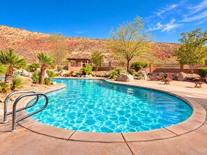A swimming pool with a clear blue water surface, surrounded by a patio area with lounge chairs and a small building. - Terra Summit w/ Rooftop Hot Tub + Lazy River (Hurricane)