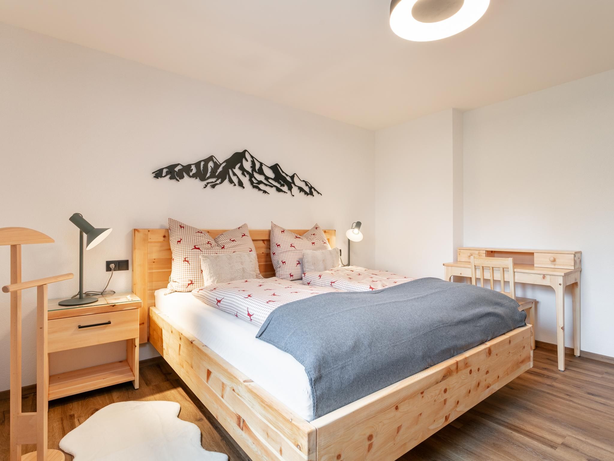Ein modernes Schlafzimmer mit einem hölzernen Bett, einem Schreibtisch und einem Stuhl.