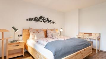 Ein modernes Schlafzimmer mit einem hölzernen Bett, einem Schreibtisch und einem Stuhl.