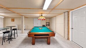 A pool table with stools, a ceiling light, and a door. - Elegant 5 Bedroom House (Hilton Head)
