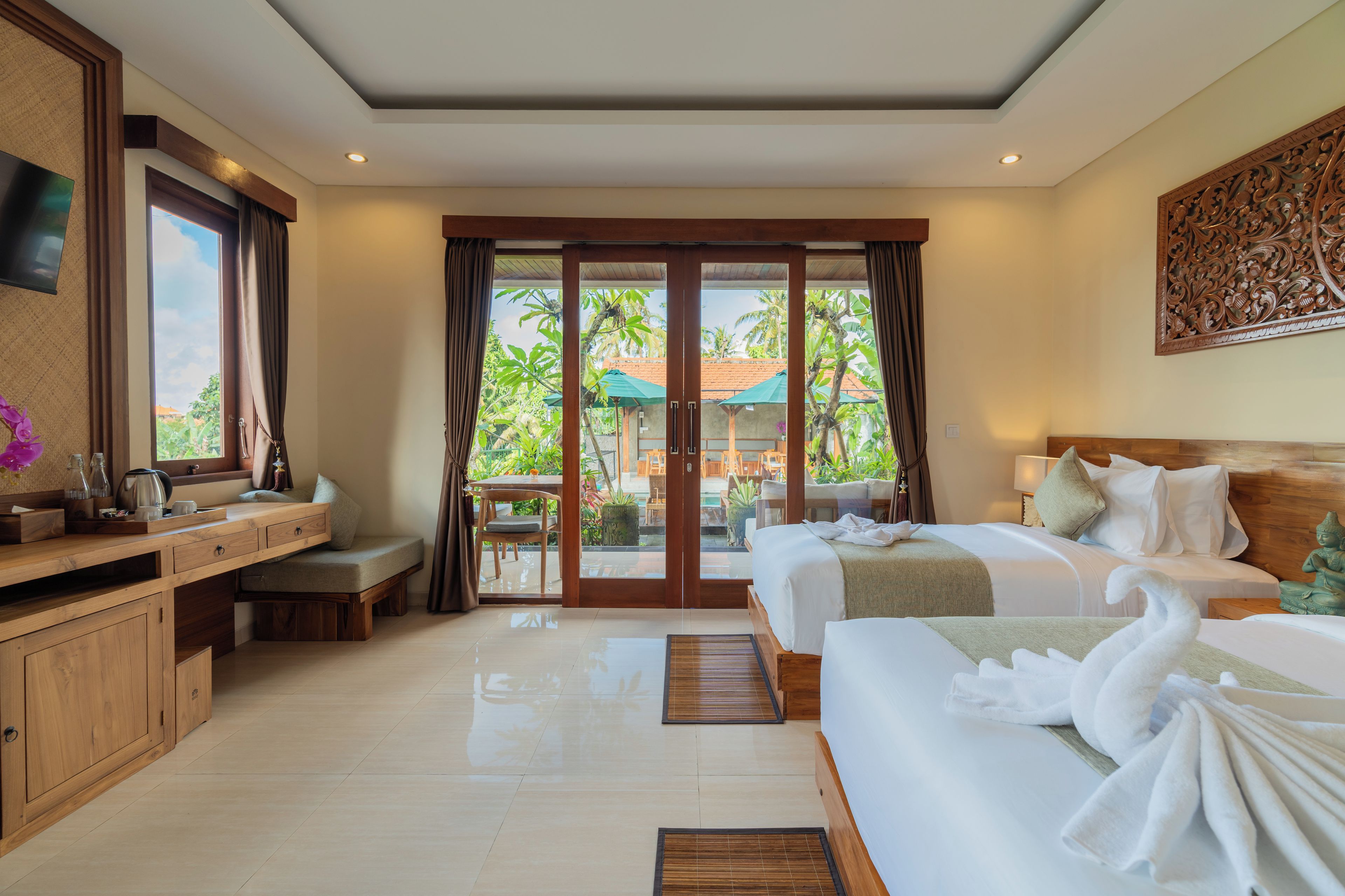 Habitación de hotel con cama, escritorio, silla y vistas al exterior.