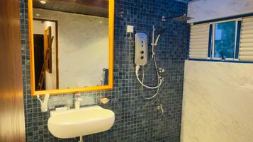 A bathroom with a tiled floor, a sink, a mirror, and a toilet.