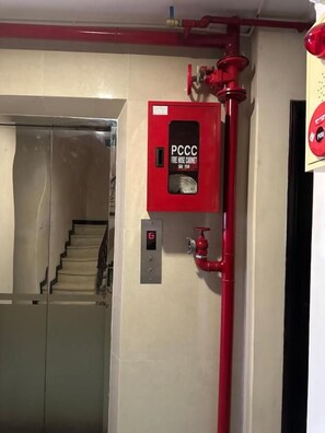 A fire safety cabinet labeled 'PCCC' and a red fire hose on the wall. - Ngoc Minh Hotel (Ben Thanh)