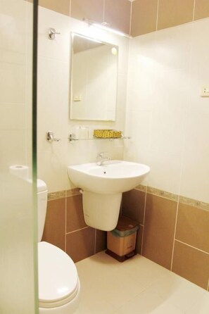 A bathroom with a white sink, a mirror, and a toilet. - Ngoc Minh Hotel (Ben Thanh)