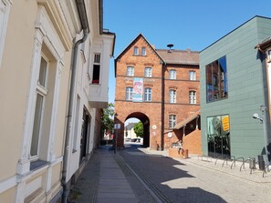 A narrow street with a brick building labeled 'Sprewe Museum' and a green building with a visible entrance. - Holiday Apartment in Lubbenau With Barbecue (Lübbenau/Spreewald)