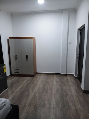 Habitació amb un armari, un llit i una porta.