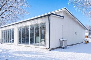 Un bâtiment moderne doté de grandes fenêtres en verre et d’une façade blanche.