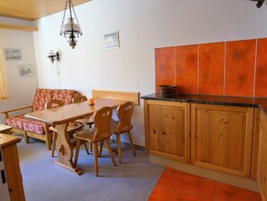 A dining area with a wooden table and chairs, a bench, and a hanging light fixture. - Paradies 026 Appartement/Fewo, Bad, WC, 4-Bettwohnung 4-Bettwohnung by Interhome (Arosa)