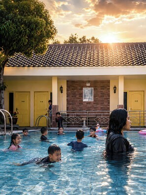 A swimming pool area with multiple doors, a brick wall, and a tiled roof.