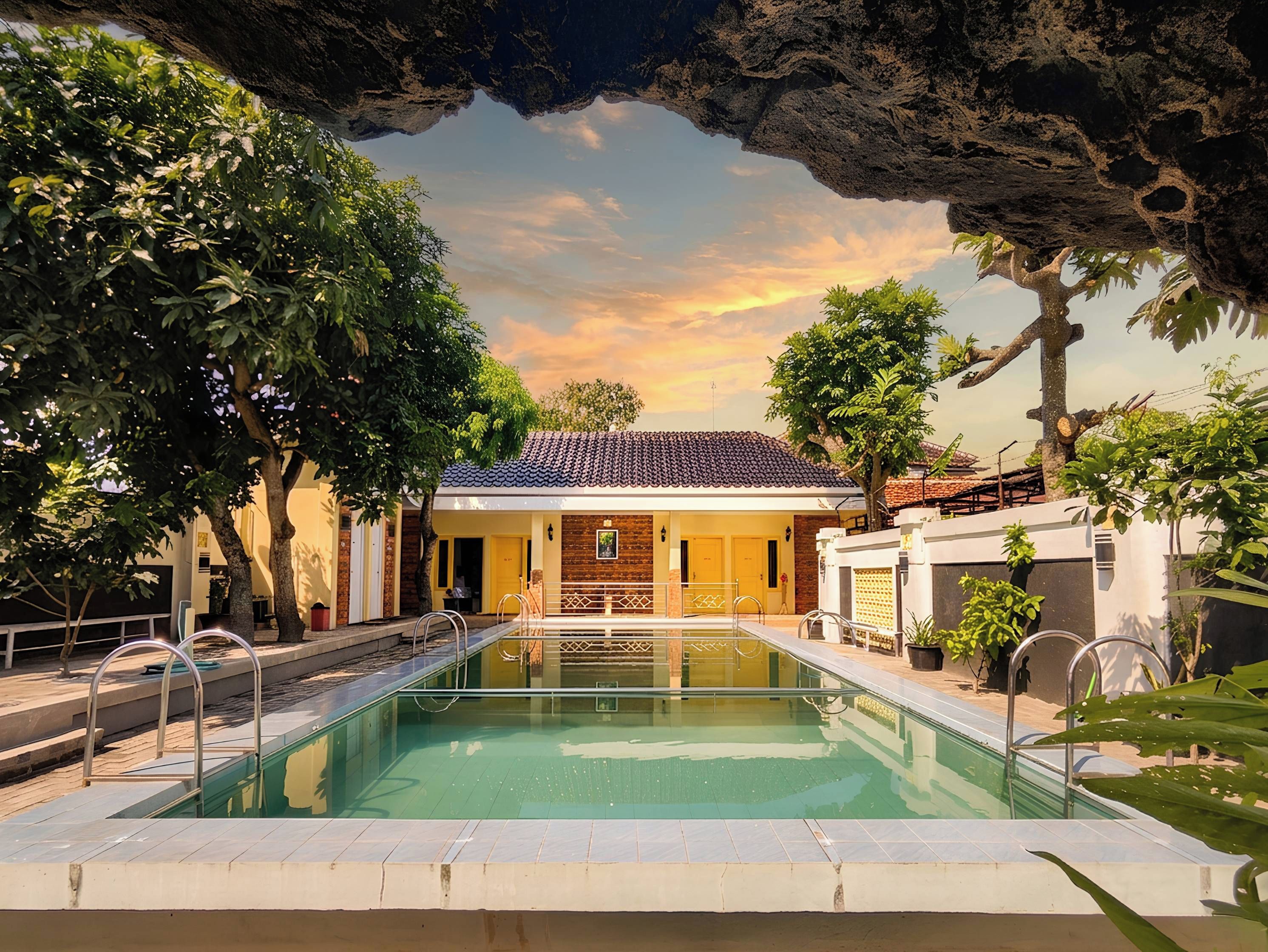 Una piscina con vista a un edificio y árboles.