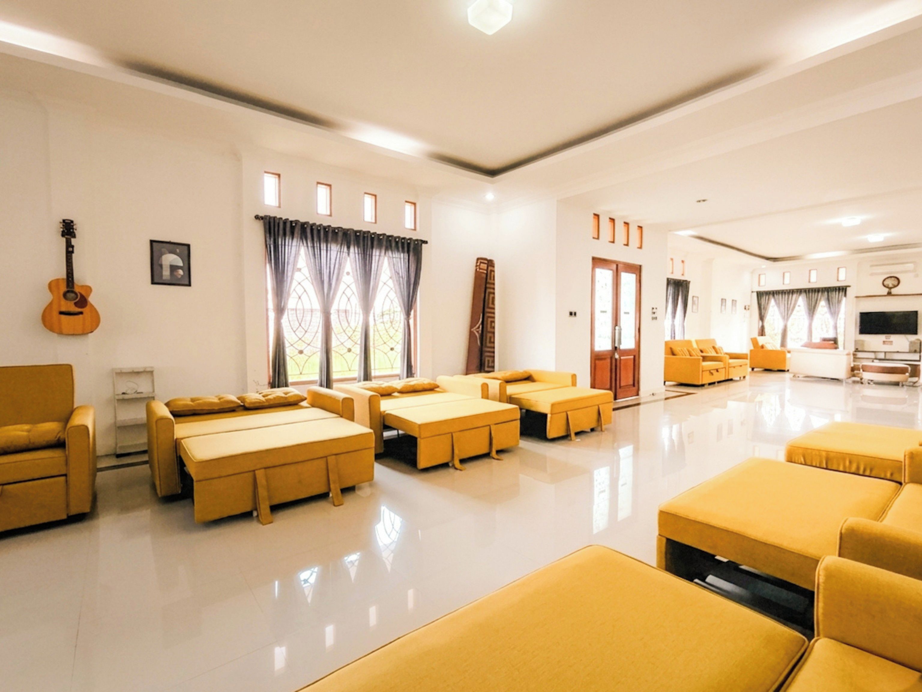 Amplia sala de estar con diversas opciones de asientos, incluyendo sofás y un sillón, dispuestas alrededor de una mesa de centro.