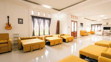Amplia sala de estar con diversas opciones de asientos, incluyendo sofás y un sillón, dispuestas alrededor de una mesa de centro.