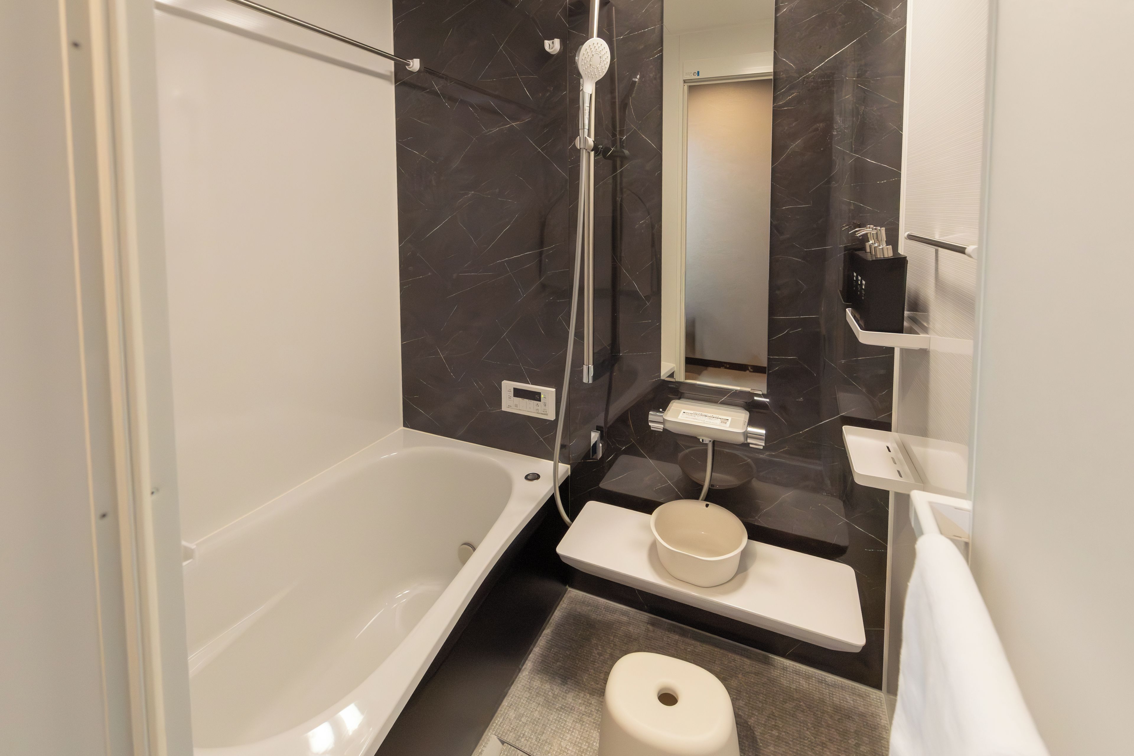Une salle de bain moderne équipée d’une baignoire, d’une douche, de toilettes et d’un lavabo.