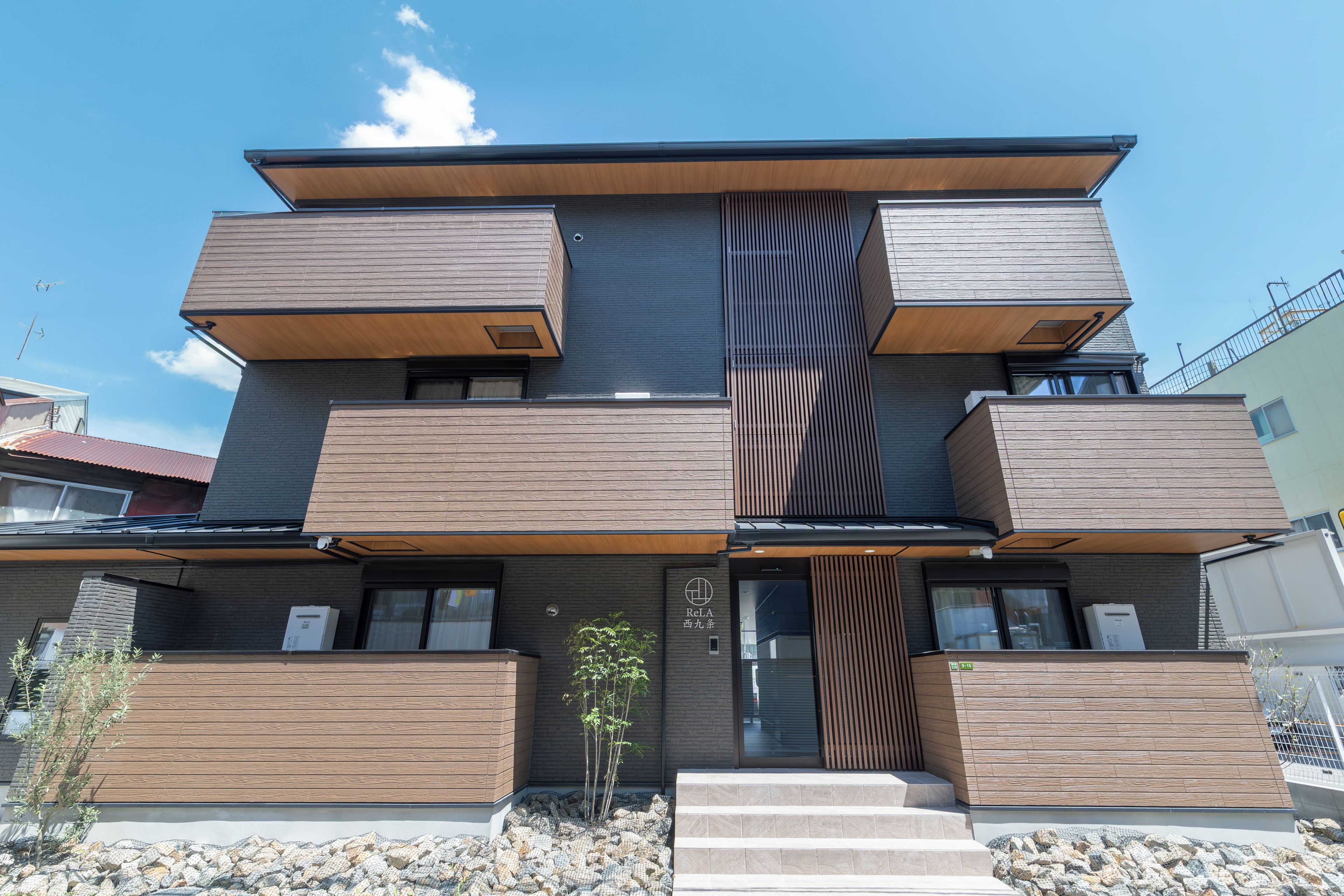 Un bâtiment moderne à plusieurs étages, doté d’un toit plat, de grandes fenêtres et d’une façade en bois.
