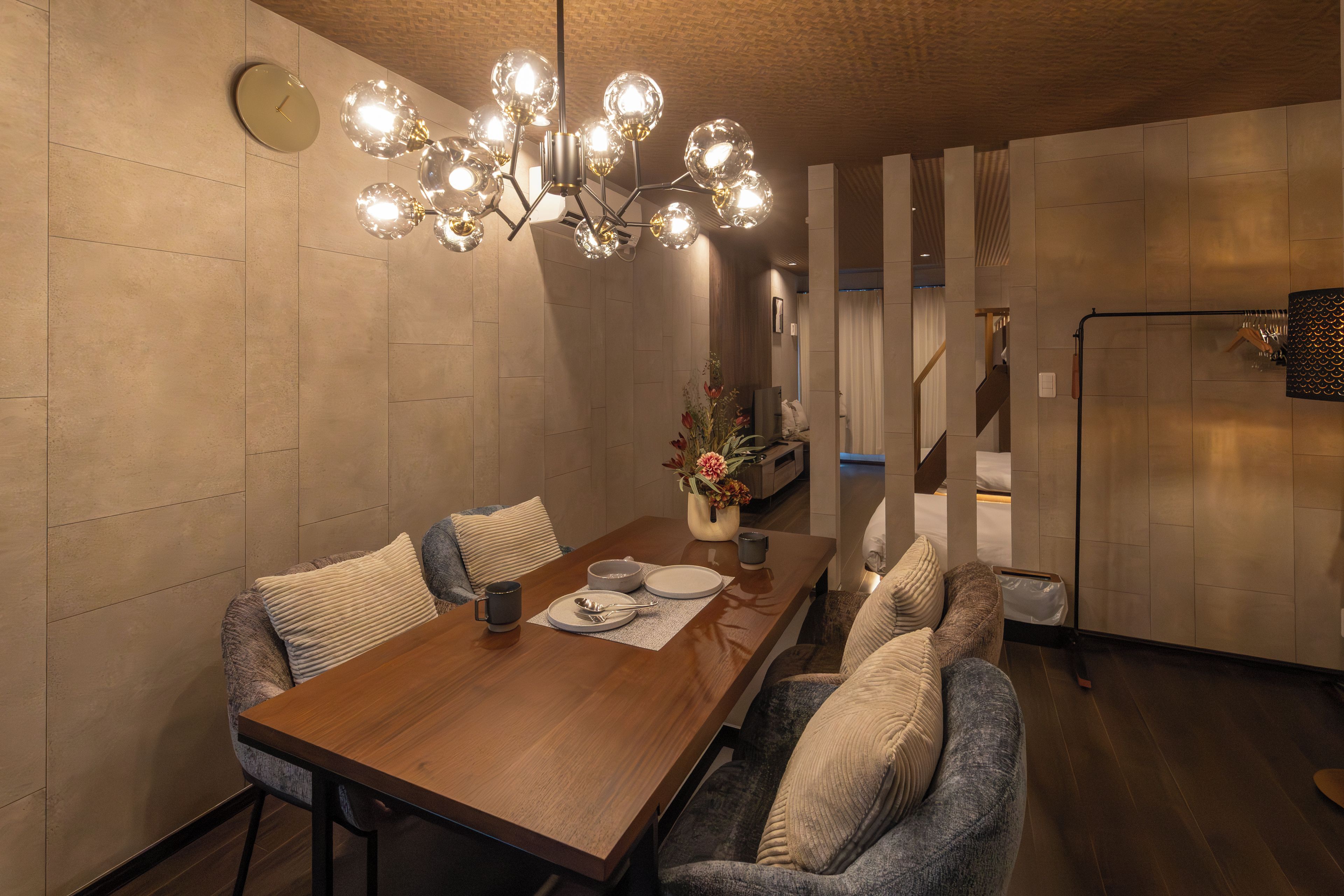 Un espace de salle à manger moderne, avec une table en bois, des chaises et un luminaire sphérique original.