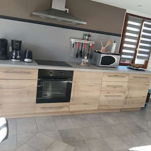 A modern kitchen with a built-in oven, a coffee maker, and a microwave. - La Fontaine du Marais Vacation Rental, located near St. Valery-sur-Somme, with free parking (Pendé)
