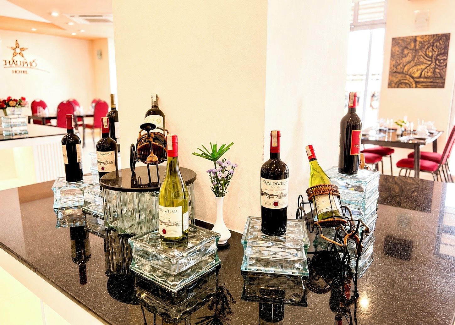 A hotel bar with multiple wine bottles displayed on glass pedestals.