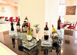 A hotel bar with multiple wine bottles displayed on glass pedestals.