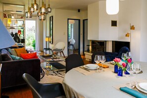 A modern dining area with a round table set for four, surrounded by comfortable seating. - Ty Maine (Saint-Malo)