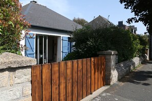 A residential property with a wooden fence, stone wall, and a blue door. - Ty Maine (Saint-Malo)