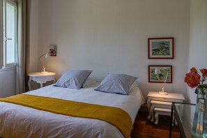 A hotel room with a bed, bedside tables, a lamp, and two framed pictures on the wall. - Ty Maine (Saint-Malo)