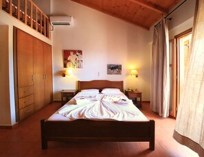 Habitación de hotel con cama de madera, dos mesitas de noche con lámparas, un armario y un cuadro en la pared.