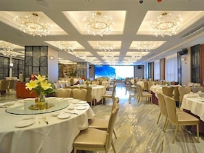 A banquet hall with round tables, chairs, and chandeliers. - Campanile Hotel (Shenzhen)
