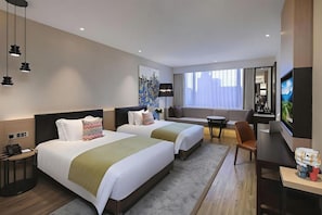 A hotel room with two beds, a sofa, a TV, and a desk. - Campanile Hotel (Shenzhen)