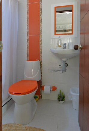 A bathroom with a toilet, sink, and mirror. - Posada J & J Forbes (San Andrés)