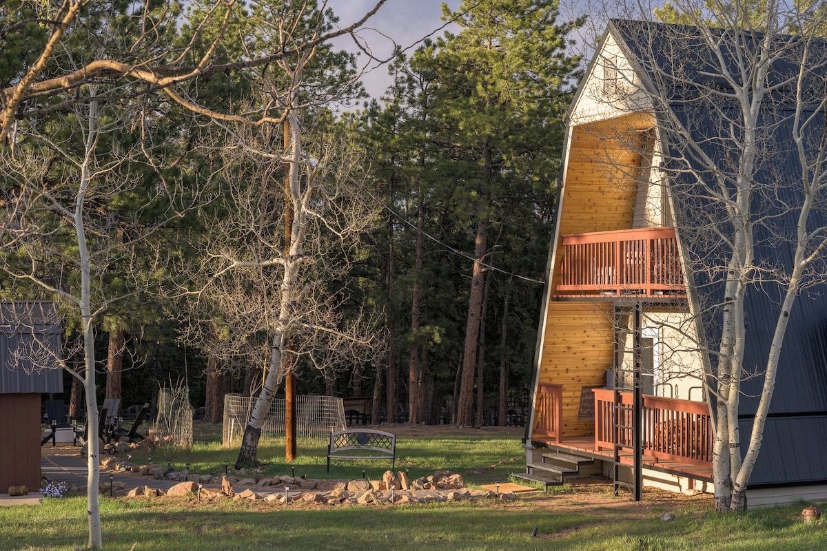 A cabin with a wooden exterior, a balcony, and a surrounding forested area.