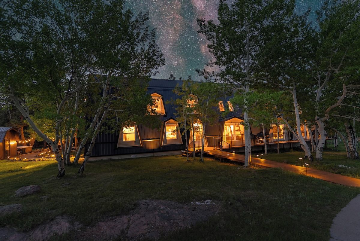 A row of treehouse-style cabins with a view of the night sky.