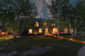 Cabañas tipo casa en los árboles con vista al cielo nocturno.