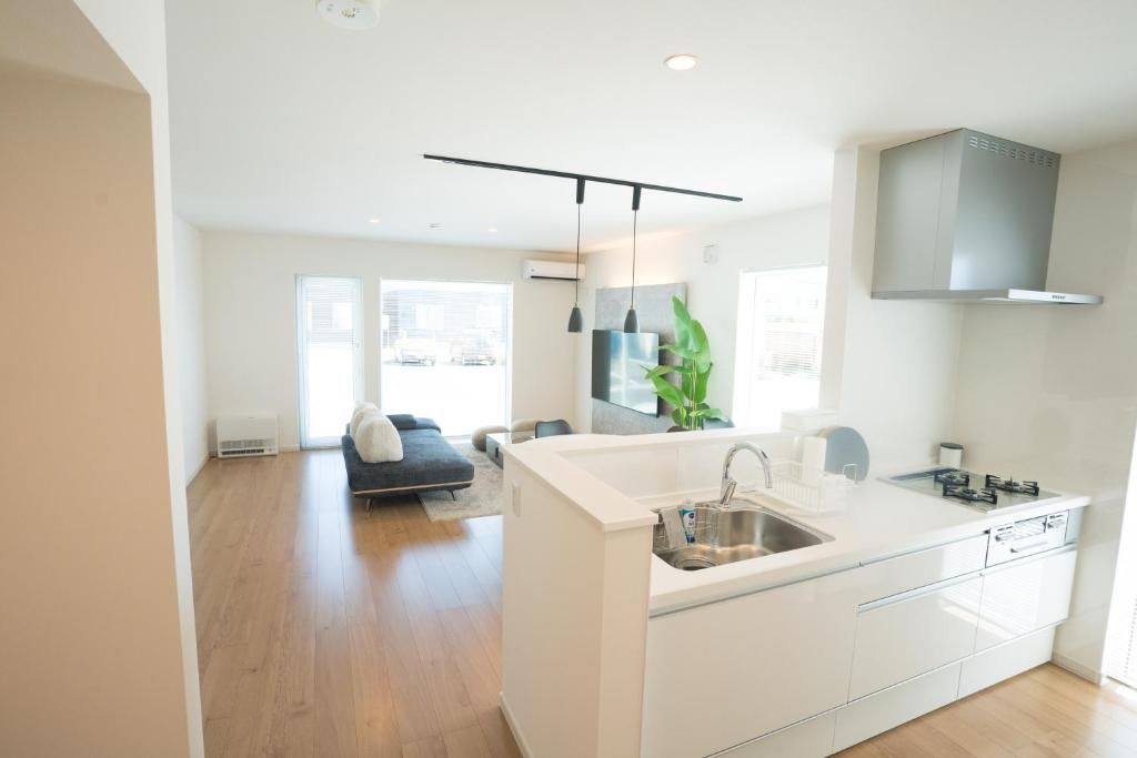 A modern kitchen with a central island, built-in appliances, and a large window providing natural light.