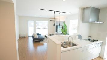 A modern kitchen with a central island, built-in appliances, and a large window providing natural light.