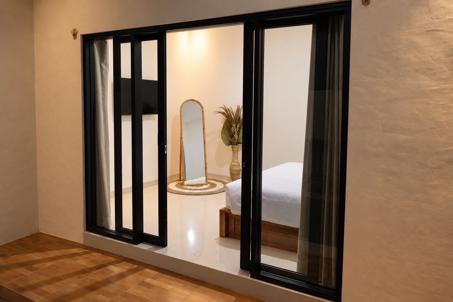 A room with a sliding door, a bed, a mirror, and a plant.