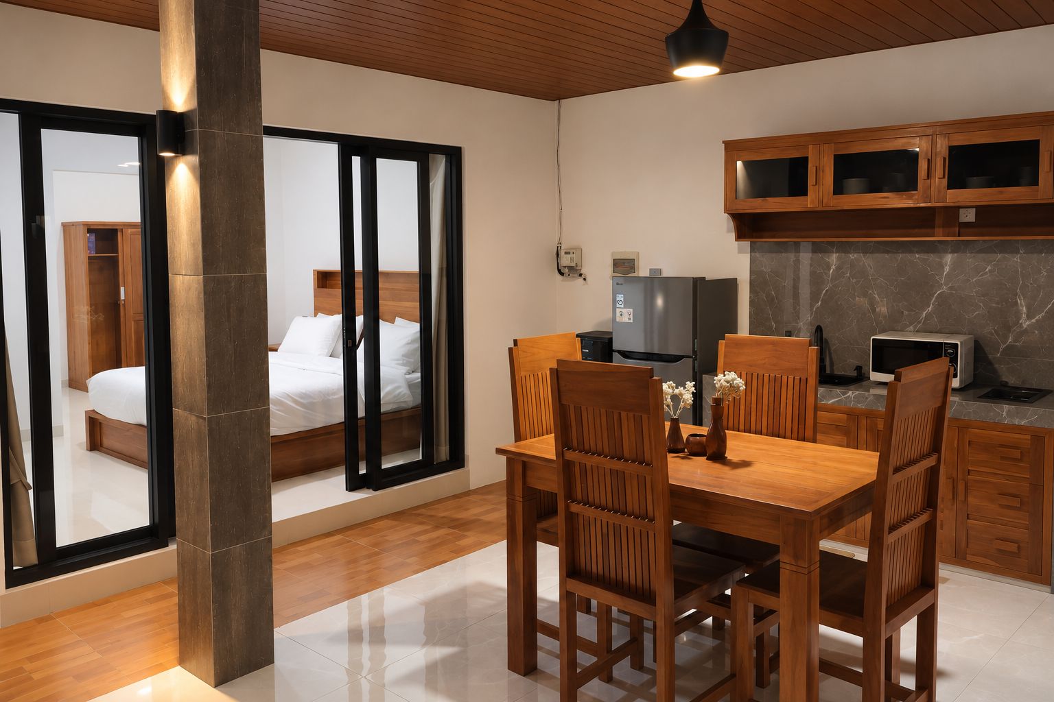 A modern room with a bed, a dining table, and a kitchen area.