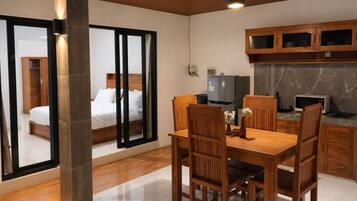 A modern room with a bed, a dining table, and a kitchen area.