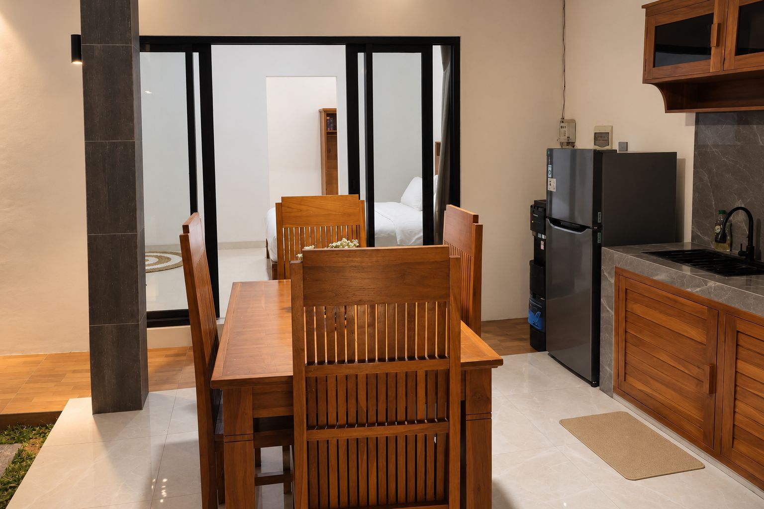 A modern kitchen with a built-in refrigerator, wooden cabinets, and a dining area with a table and chairs.