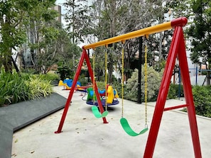 Un parque infantil con columpios y un tobogán.