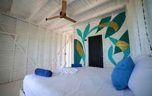 A room with a bed, a towel, a white swan decoration, and a ceiling fan. - El Faro by OOL Hotels (Isla Holbox)