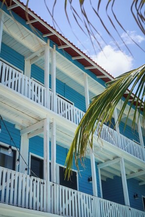 A multi-story building with balconies and a red roof. - El Faro by OOL Hotels (Isla Holbox)