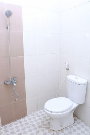 A bathroom with a toilet, a shower, and a checkered floor. - Signature Jogja (Pogung Lor)