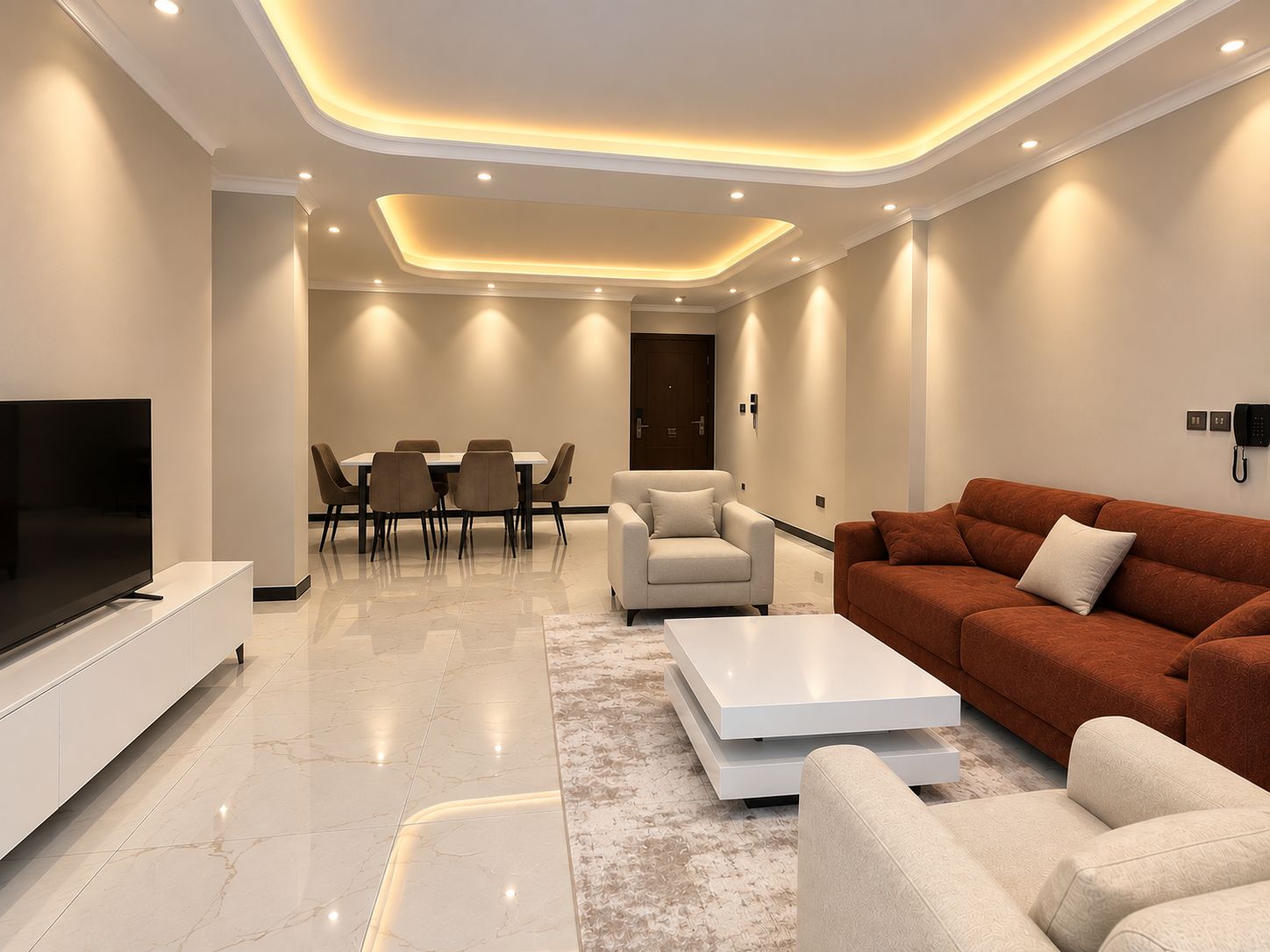 Una sala moderna con televisor de pantalla plana, un sofá, una mesa de centro y una zona de comedor con sillas y una mesa.