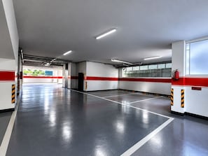 Een parkeergarage met duidelijke markeringen, een brandblusser en een goed zichtbare uitgang.