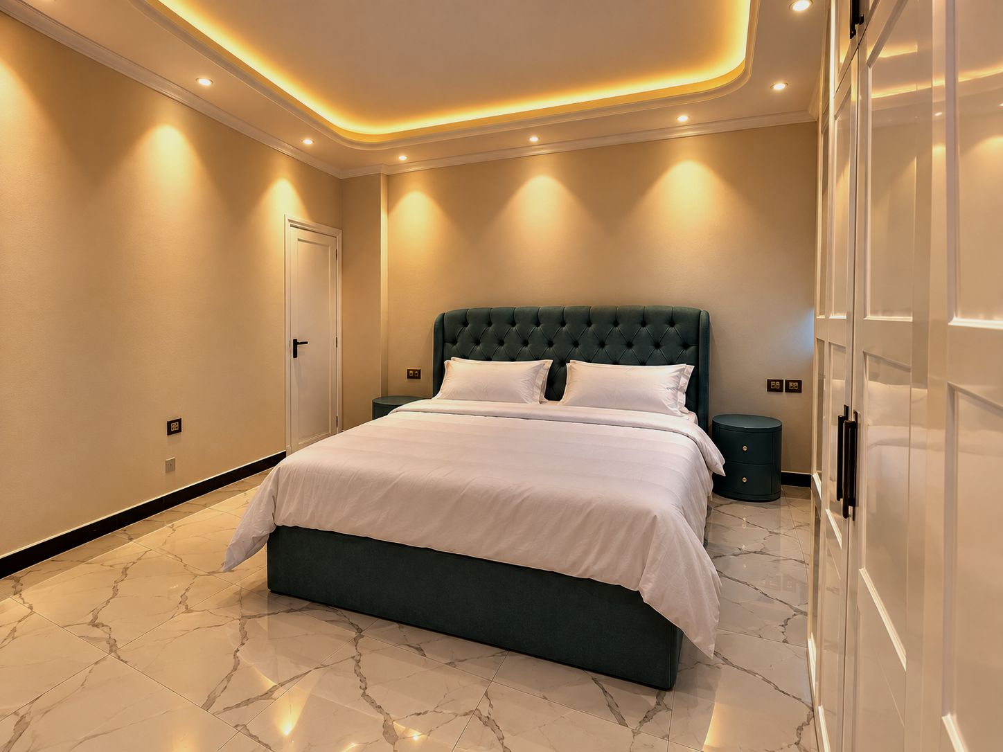 Un dormitorio moderno con una cama grande, suelo de mármol e iluminación empotrada en el techo.