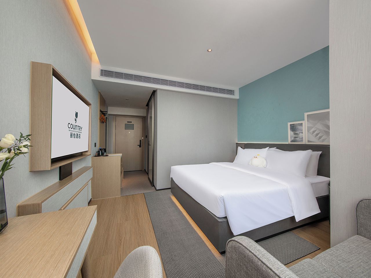 Une chambre d’hôtel équipée d’un lit, d’un bureau, d’une chaise, d’une télévision et d’une porte donnant accès à une salle de bain.