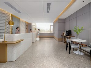 A modern hotel lobby with a reception desk, seating area, and a large window providing a view. - Country Inn & Suites Huashi Metro (guangzhou)